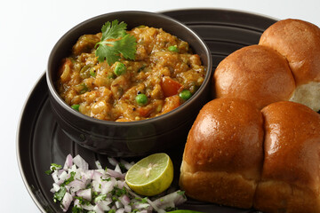 Pav Bhaji is a fast food dish from India, Thick and spicy vegetable curry, fried and served with a soft bread roll,Bun, Paav and butter. selective focus