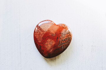 Pierre polie jaspe rouge en forme de coeur sur un fond blanc - Minéral naturel