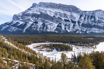 Banff National Park beautiful landscape. Panorama view Mount Rundle valley forest and frozen Bow River in winter. Hoodoos Viewpoint, Canadian Rockies.