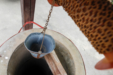 Shadow depth of field (selective focus) details with an old well with an iron bucket in rural Romania © MoiraM