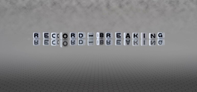 Record Breaking Word Or Concept Represented By Black And White Letter Cubes On A Grey Horizon Background Stretching To Infinity