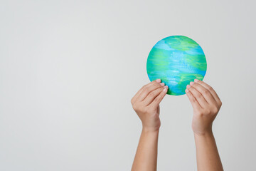 Woman hands holding paper colored earth element to empowered saving the world concept. Love and care to the earth.