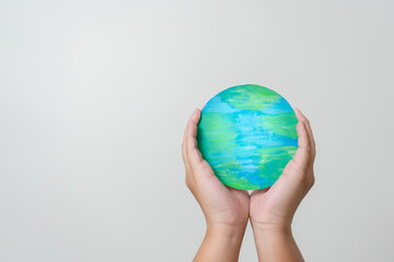 Woman hands holding paper colored earth element to empowered saving the world concept. Love and care to the earth.