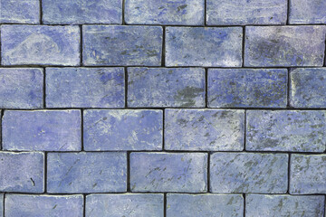 The background texture of a brick wall is light blue , purple shades are large blocks