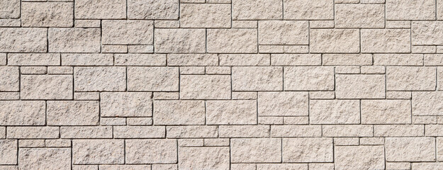The texture of the surface of a white and yellow brick concrete wall, cement pattern with cracks on the background with space to copy, panoramic view