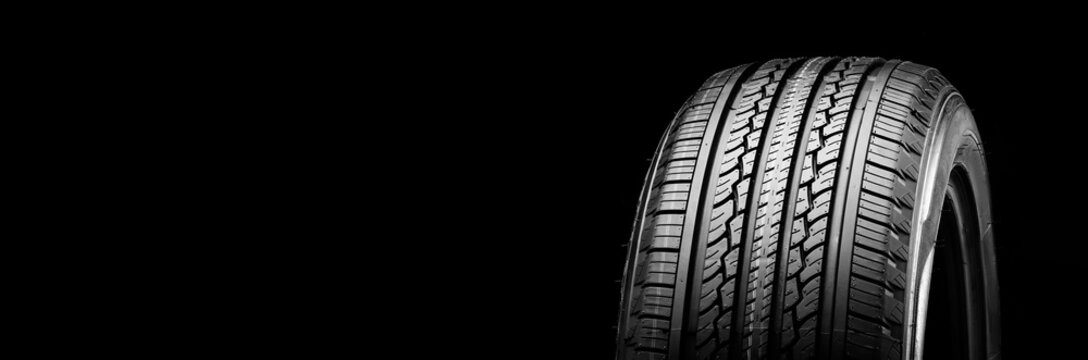 all-season new tire on a black background kopi space panorama auto parts