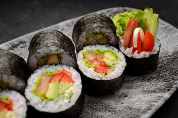 Sushi roll Yasai on a dark plate
