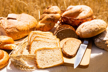 lot of different flavored bread, wheat, rye, on the table in the field outside