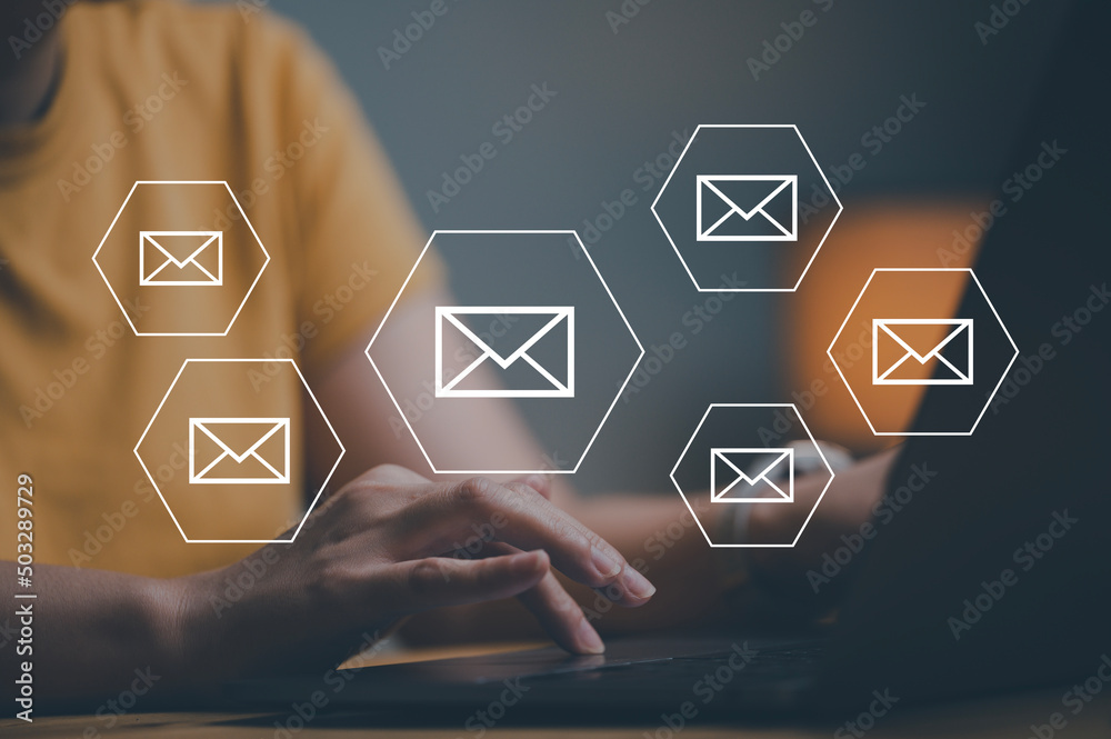 Aufkleber woman hands using laptop typing on keyboard and surfing the internet on office table with email icon