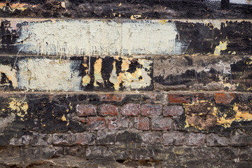 A fragment of a layered brick wall in black, white, yellow and red tones