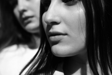 Black and white portrait of two girls. Girls in white dresses walking in the park