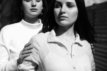 Black and white portrait of two girls. Girls in white dresses walking in the park