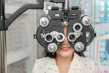 Young female customer being examined visual test using Bifocal Optometry eyesight measurement...