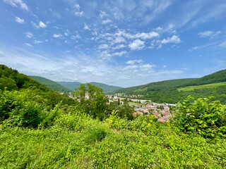 Fototapeta na wymiar Aerial point of view on Buhl (Alsace, France), its green forest and its mountains, its blue sky, on a sunny summer day