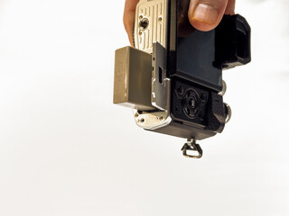 holding a mirrorless camera with battery door compartment open to change the battery