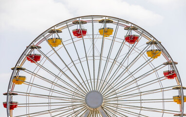 Yellow and red carts on a large white Ferris wheel