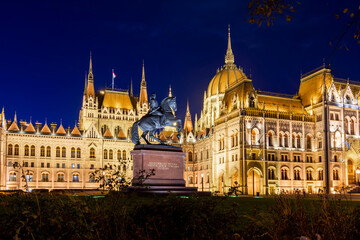 Rakoczi Ferenc monument with inscription "Ancient wounds of the noble Hungarian nation are reclaimed" in front of Hungarian Parliament at night, Budapest, Hungary