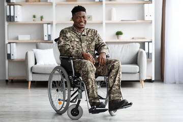 Happy black soldier sitting in wheelchair, clinic interior
