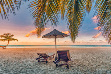 Beautiful tropical sunset landscape, couple sun beds, loungers, umbrella under palm tree. White sand, seaside horizon, colorful twilight sky, calm and relax, recreational. Inspirational beach resort 