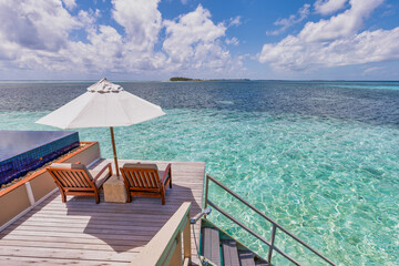 Deck chair with umbrellas at Maldives resort with infinity pool and beach, sea sky view. Luxury...