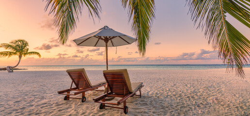 Beautiful panoramic nature. Tropical beach sunset as summer island landscape with chairs umbrella palm leaves calm sea shore, coast. Luxury travel panoramic destination banner for vacation or holiday