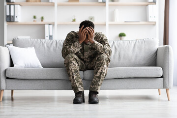 Depressed military black man covering his head with palms