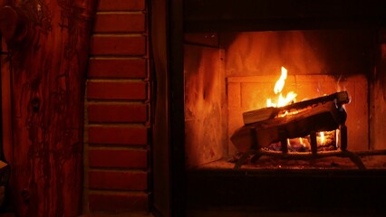 Fire in brick fireplace, firewood burning, wood blazing in cozy lodge, hut or cabin. Romantic weekend on winter holidays, fireside in warm cosy cottage house. Seamless looped cinemagraph background. - obrazy, fototapety, plakaty