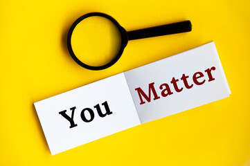 You matter text on notepad with magnifying glass on yellow cover background.