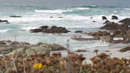 Rocky craggy pacific ocean coast, sea water waves crashing on rocks, 17-mile drive, Monterey, California USA. Gloomy nature near Point Lobos, Big Sur, Pebble beach. Dramatic cloudy rainy cold weather.