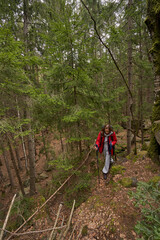 Lady with telescoping walking poles making way through forest