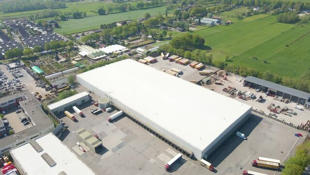 Aerial of trucks parked on lot of large logistical center
