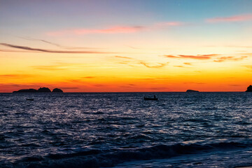 Panoramic sunset view from village of Positano at Amalfi Coast, Italy, Campania, Europe. Fishermen boat silhouette on Tyrrhenian, Mediterranean Sea. sun down behind the Li Galli islands. Vacation vibe