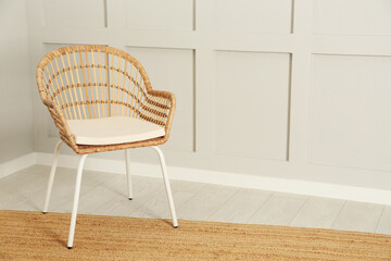 Stylish wicker armchair near light wall in room. Space for text - obrazy, fototapety, plakaty