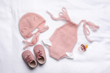 Flat lay composition with child's clothes and accessories on white fabric
