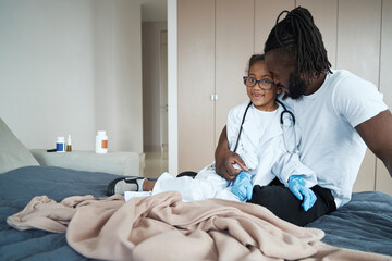 Adult African American man hugging his little daughter