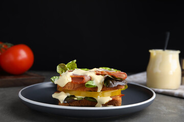 Delicious sandwich with vegetables, ham and mayonnaise served on grey table
