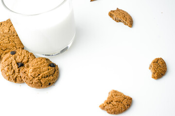 Chocolate chip cookies with glass of milk on wood plate and isolated white background. 