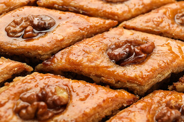 Delicious honey baklava with walnuts as background, closeup