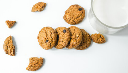 Chocolate chip cookies with glass of milk on wood plate and isolated white background. 