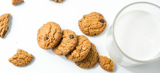 Chocolate chip cookies with glass of milk on wood plate and isolated white background. 
