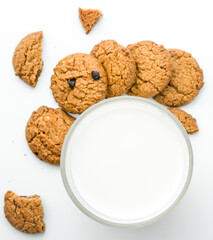 Chocolate chip cookies with glass of milk on wood plate and isolated white background. 