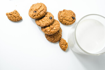 Chocolate chip cookies with glass of milk on wood plate and isolated white background. 