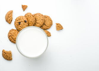 Chocolate chip cookies with glass of milk on wood plate and isolated white background. 