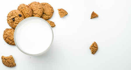 Chocolate chip cookies with glass of milk on wood plate and isolated white background. 