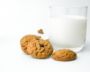 Chocolate chip cookies with glass of milk on wood plate and isolated white background. 