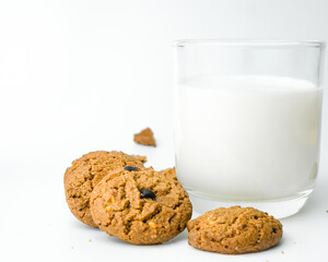 Chocolate chip cookies with glass of milk on wood plate and isolated white background. 
