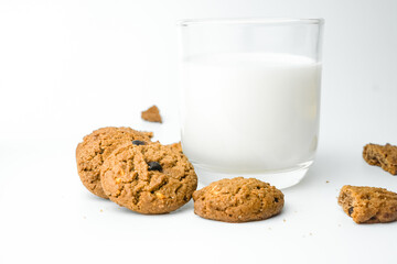 Chocolate chip cookies with glass of milk on wood plate and isolated white background. 