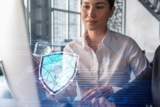 Businessman and businesswoman working together to protect clients confidential information and cyber security. IT hologram padlock icons over office background with panoramic windows.