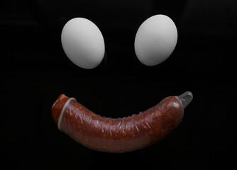 two white eggs and sausage – smiling food. smiley face idea. condom on sausage. sex idea, sexual...