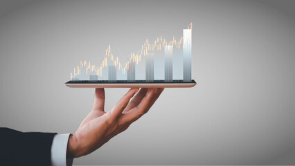 Hand of businessman holding tablet analysis stock market graph growth and increase of chart...
